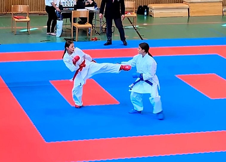 Zwei Kämpferinnen bei einem Kumite-Wettkampf auf blau-roter Wettkampfmatte